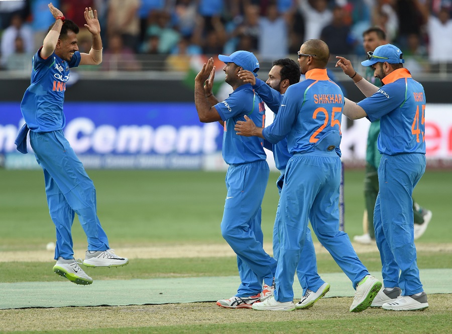Indian cricketer Yuzvendra Chahal (L) celebrates with teammate after dismissing Pakistan batsman Shoaib Malik. PHOTO: AFP
