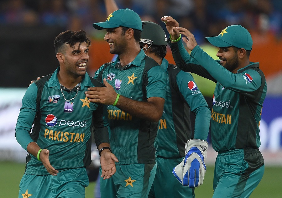 Pakistan cricketer Shadab Khan (L) celebrates with teammates after he dismissed unseen Indian cricket team captain Rohit Sharma. PHOTO: AFP