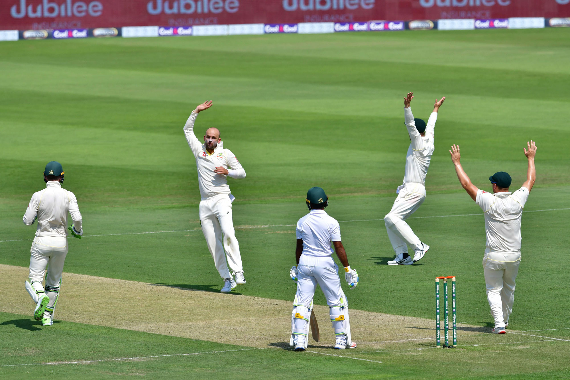 Australia cricketer Nathan Lyon (2nd L) celebrates after he dismissed Pakistan cricketer Asad Shafiq during day one of the second Test cricket match in the series between Australia and Pakistan at the Abu Dhabi Cricket Stadium in Abu Dhabi on October 16, 